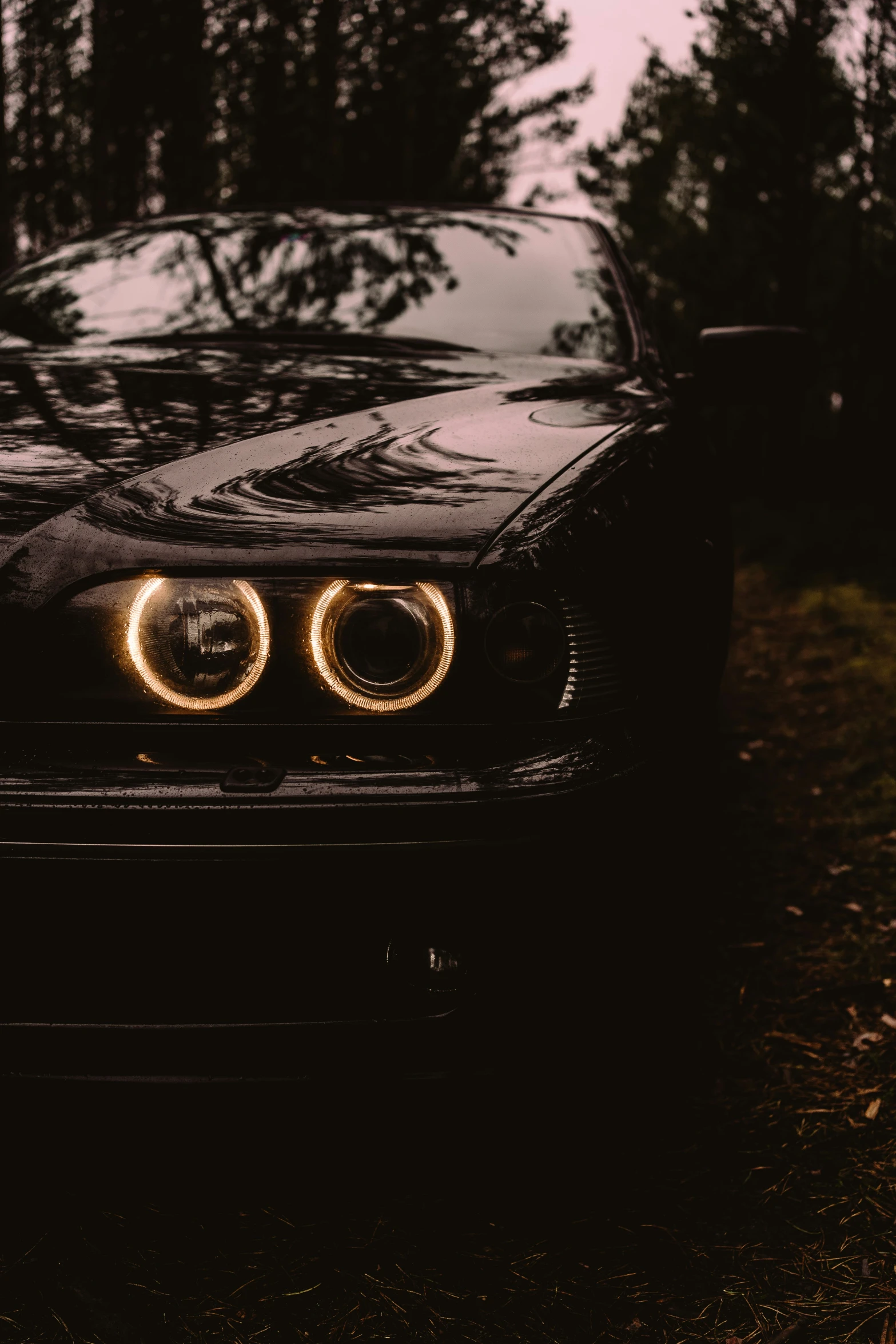 a black car with headlight up on a grassy field