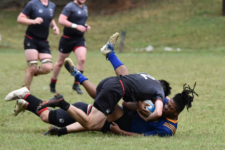 an athlete is in action on the ground as others look on