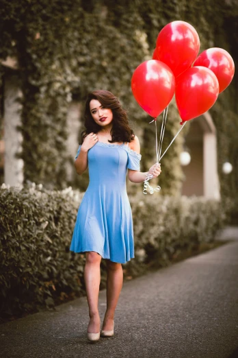 a woman with five red balloons in the shape of the number one
