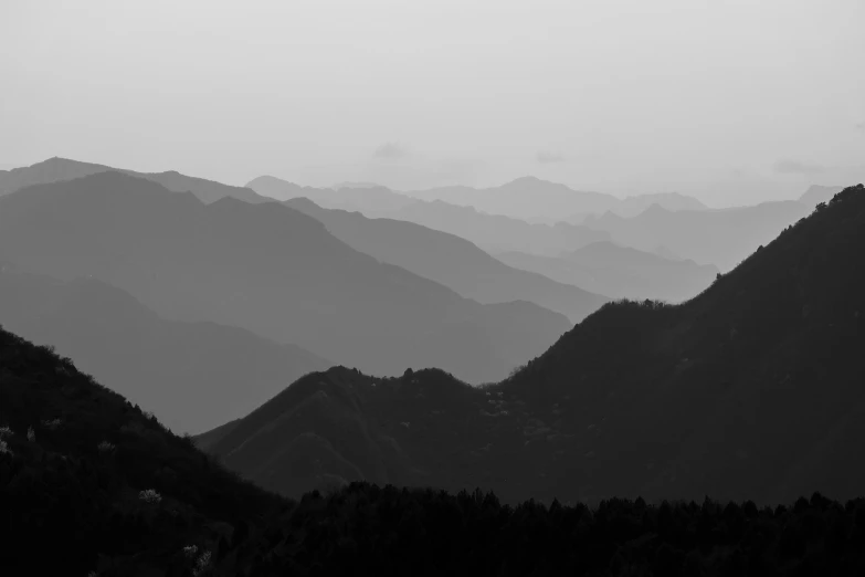 a black and white view of the mountains covered in fog