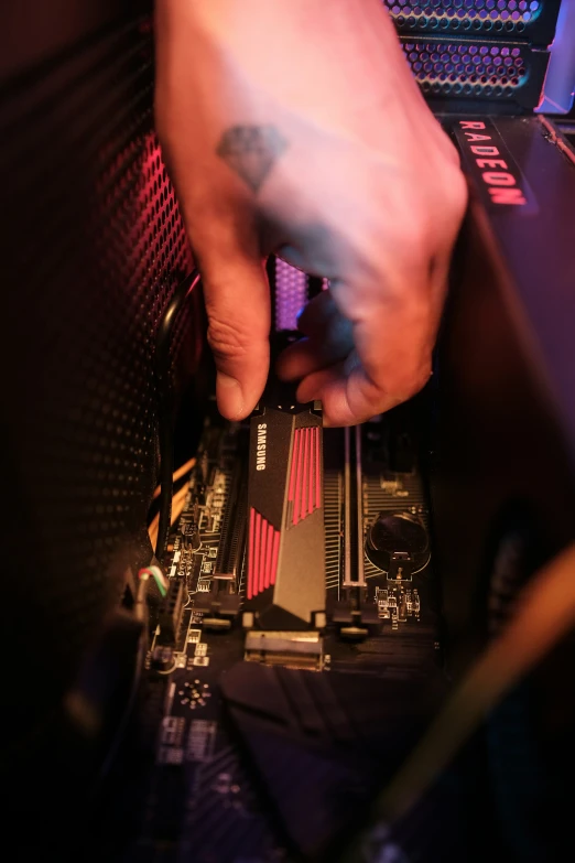 someone putting their fingers on a hard drive in the back of a computer