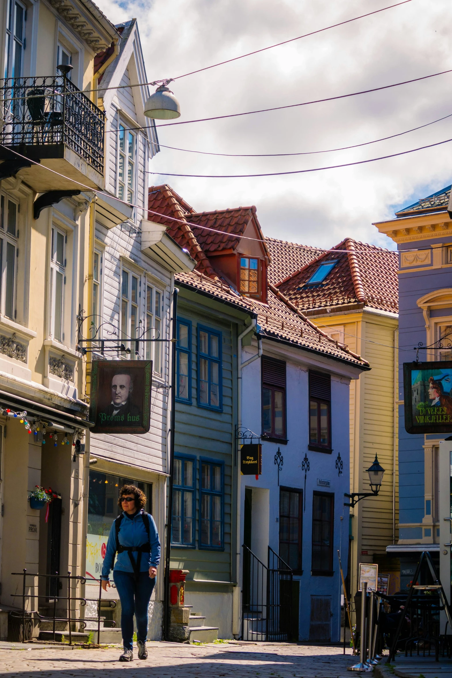 a woman walking down a street next to tall buildings