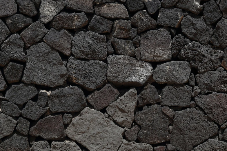 large, grey rocks are gathered together on the ground