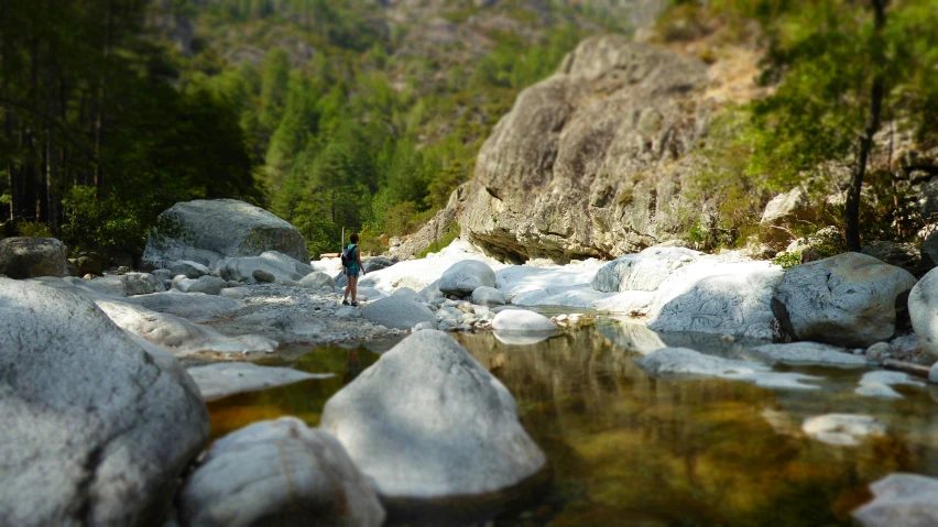 a person standing on a rocky river bank