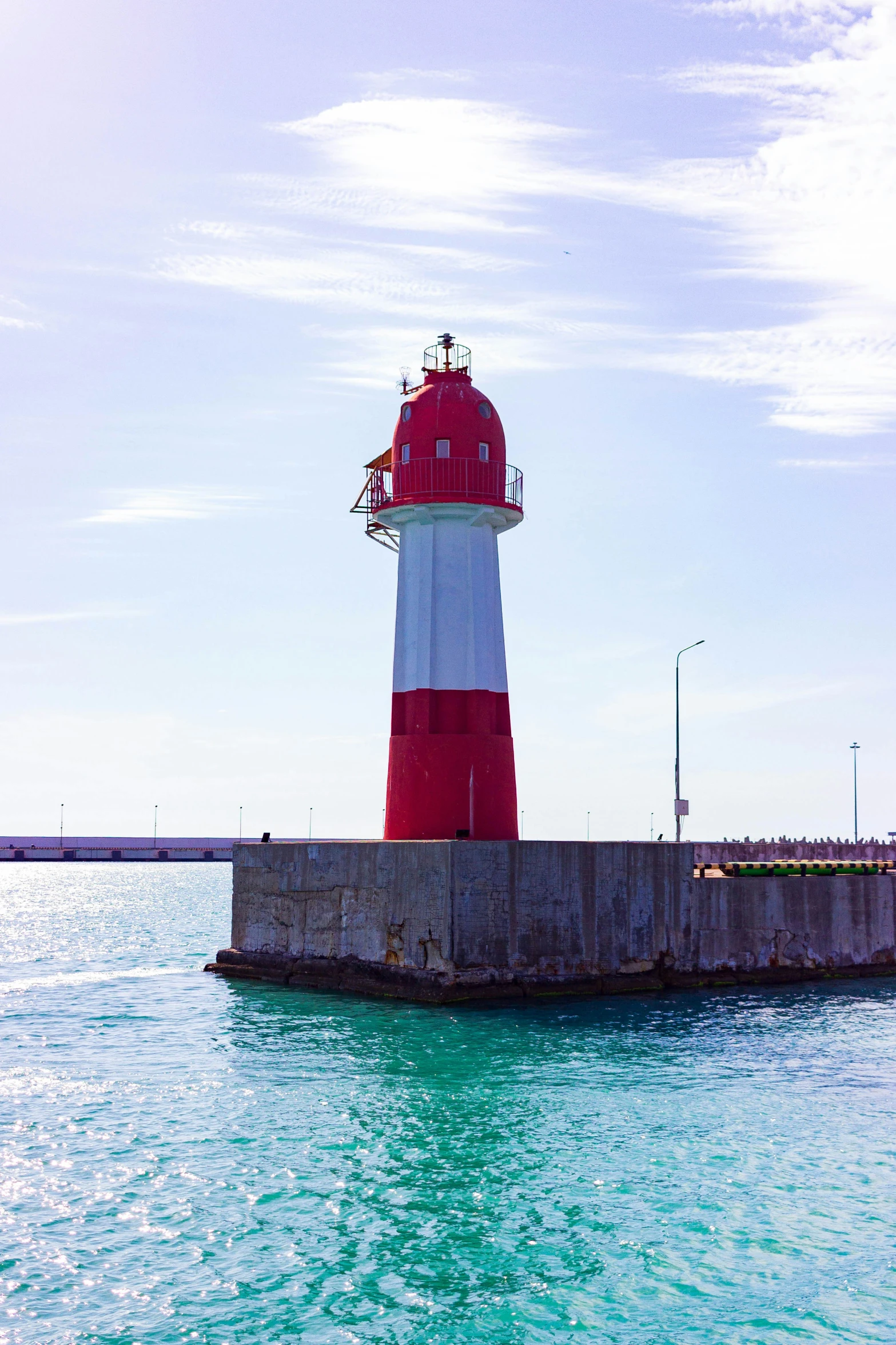 a red and white light house next to a bridge