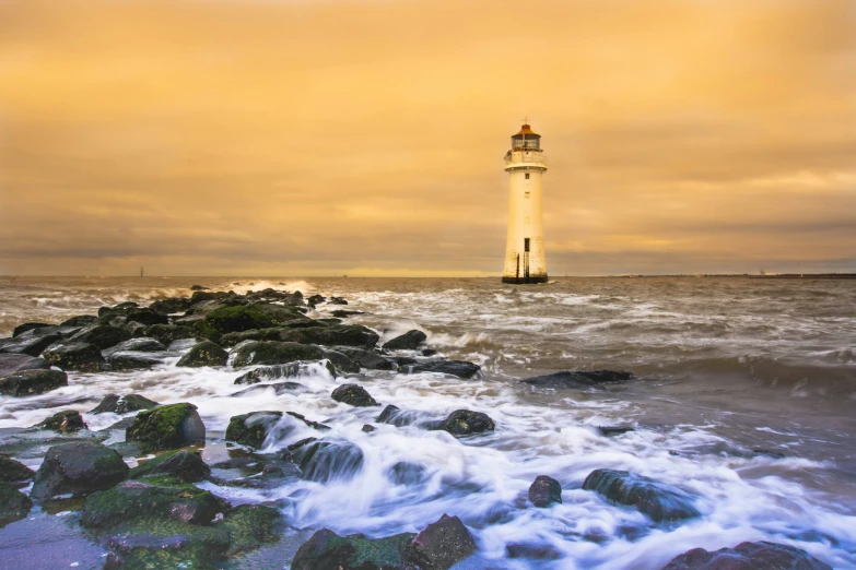 the small light house is on top of a large hill by the ocean