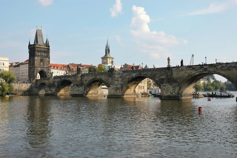 bridge over river with boats and city skyline in the background