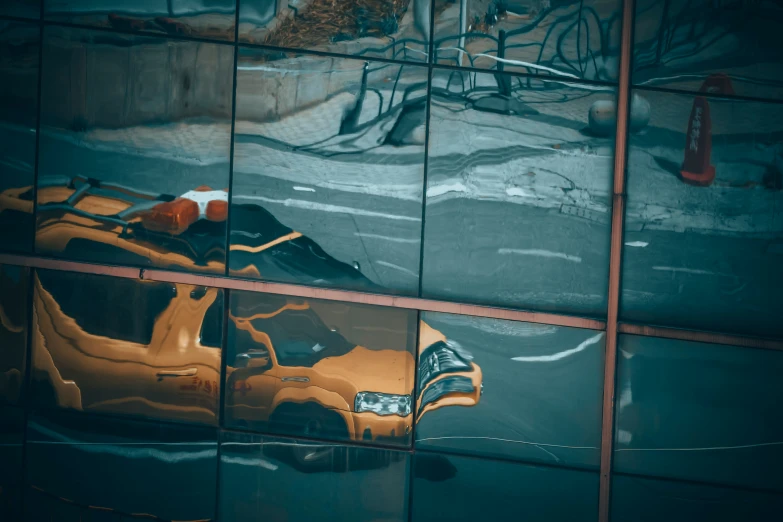 a reflection of a yellow car in an office building