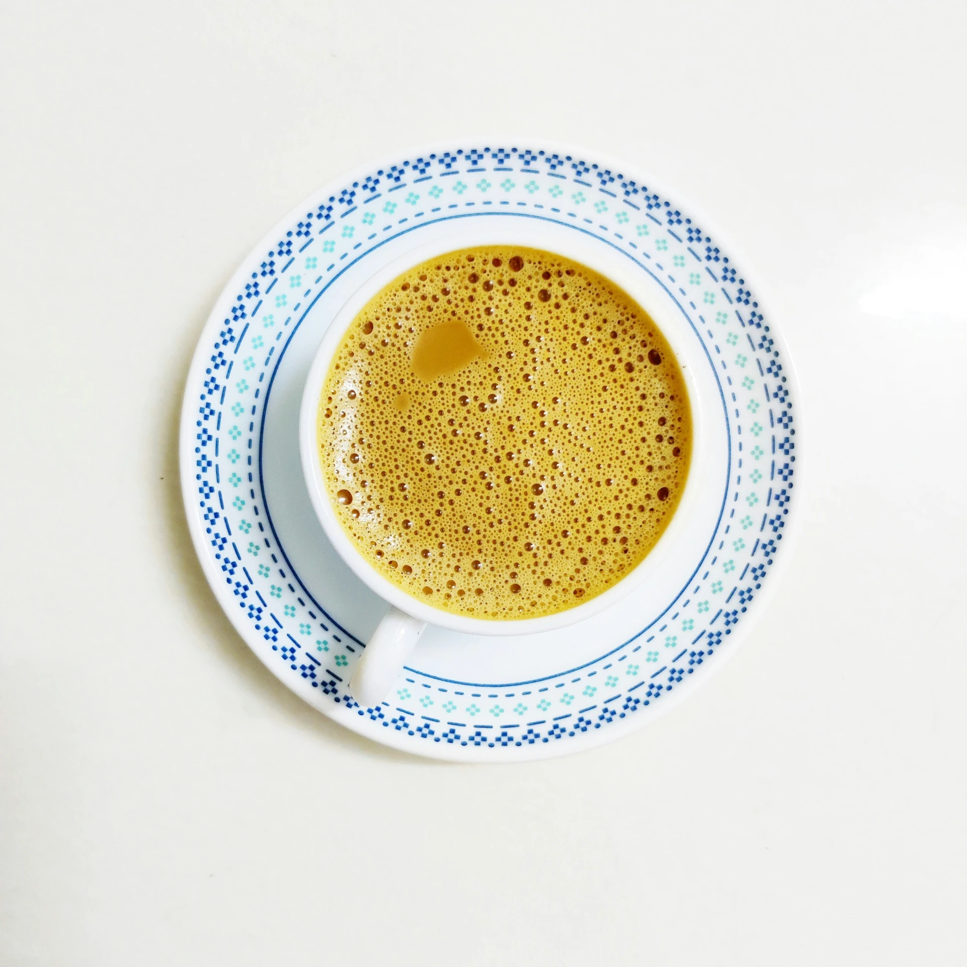 cup of coffee sits on a saucer on the table