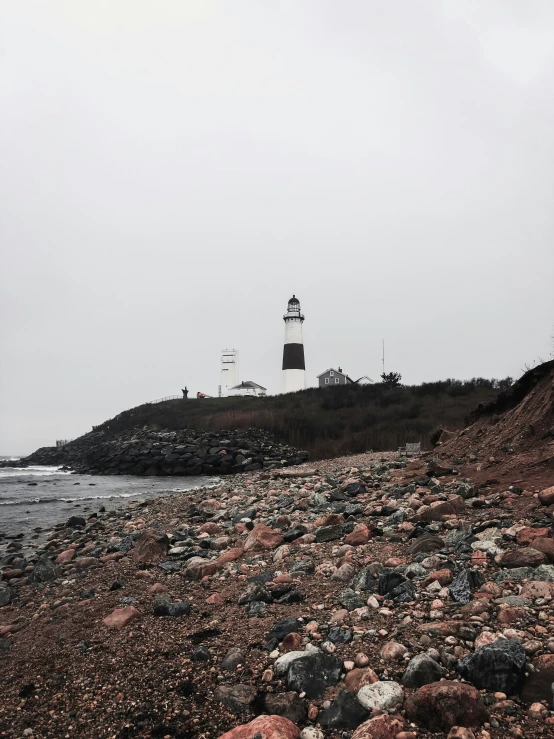 the lighthouse on top of a rocky mountain