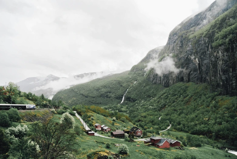 a view of some mountains with fog hanging over them