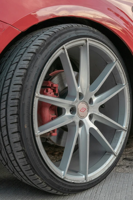 a red sports car wheel is shown from up close