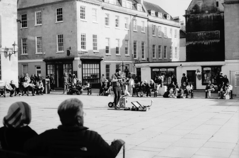 people standing around in a plaza near several buildings