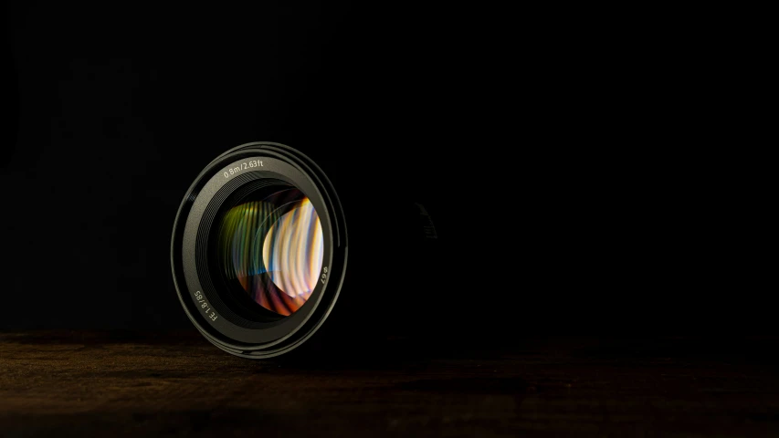 a black lens with a circular pattern in the center and reflection on the bottom