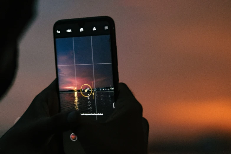 person taking a po of night scene with smartphone