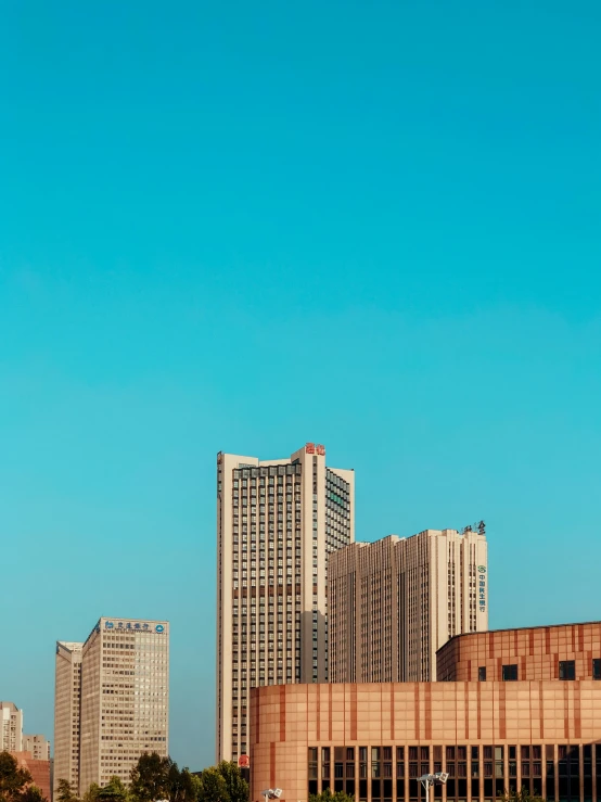 a plane flying past a tall building near other buildings