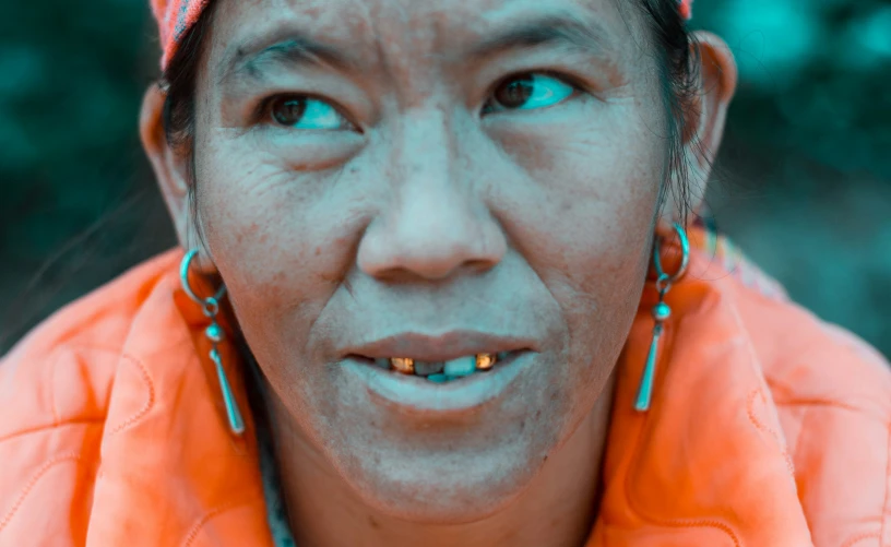 an older asian woman wearing blue and orange jewelry