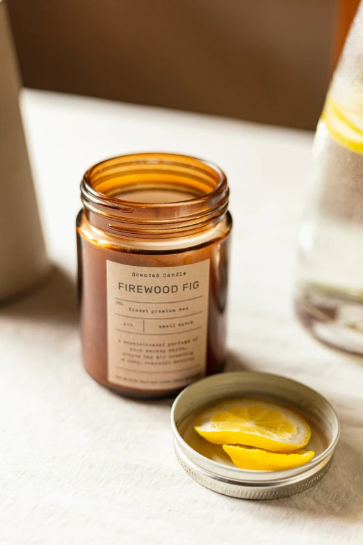 a jar of yellow liquid with a small bowl of slices of lemon