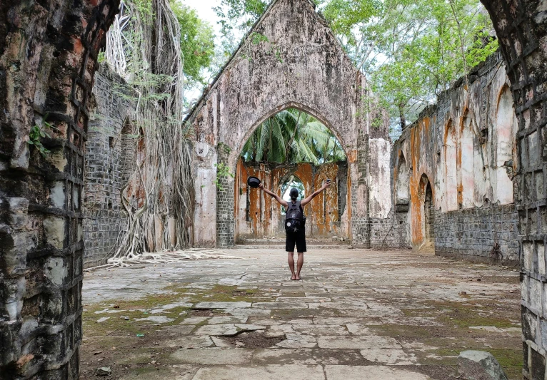 a woman with an umbrella stands near ruins