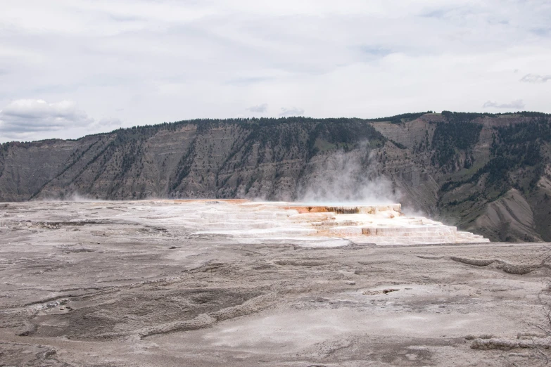 an open crater has steam rising from it