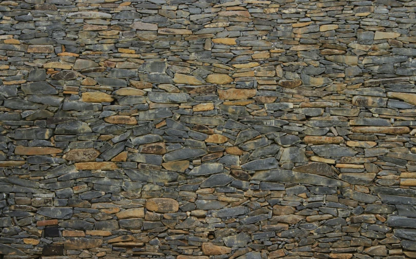 stone wall made of small rocks with brown pats