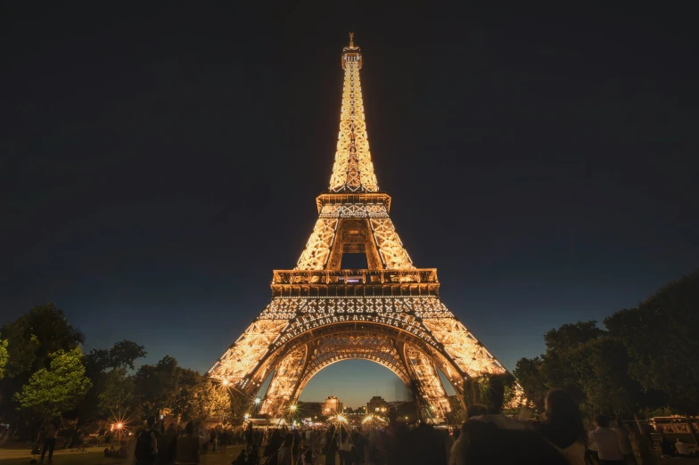 the eiffel tower has people standing underneath it