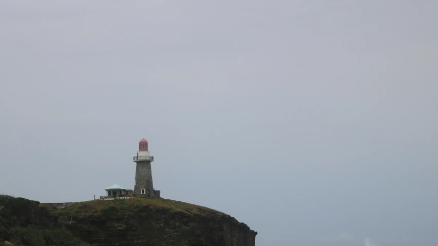 there is a small light house on top of a hill