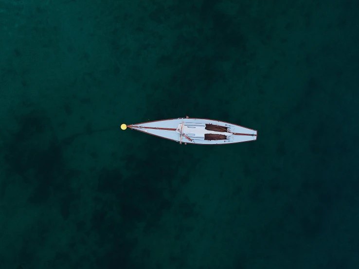 a small boat in the water from above