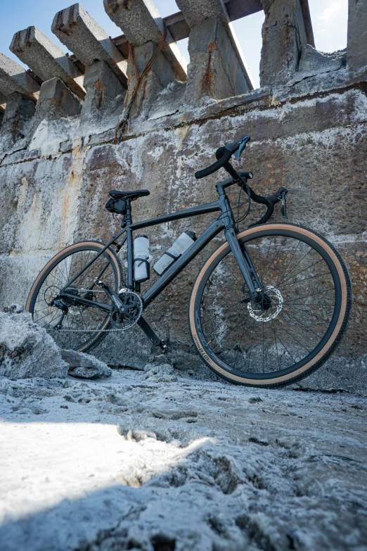 a bike parked by a large building covered in snow