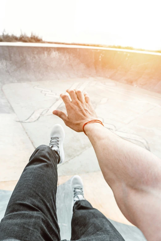 someone standing next to a skateboard holding their hand out