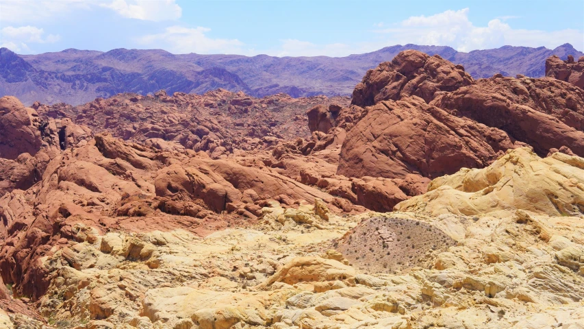 rocky hills and arid terrain with mountain range in background