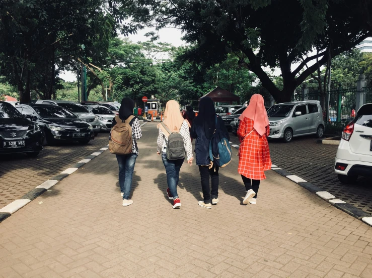 a group of people walking down a street with cars