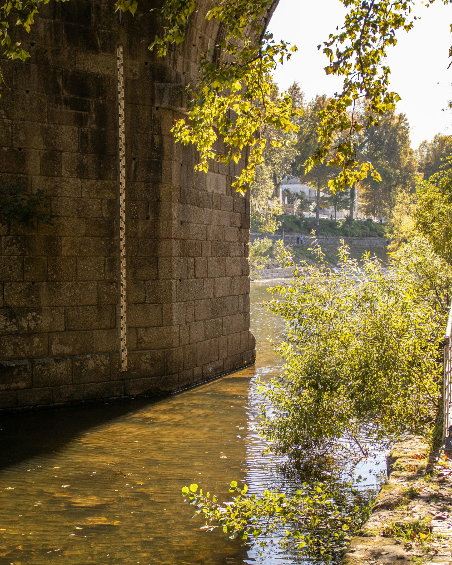 a view of a river and bridge from the side walk