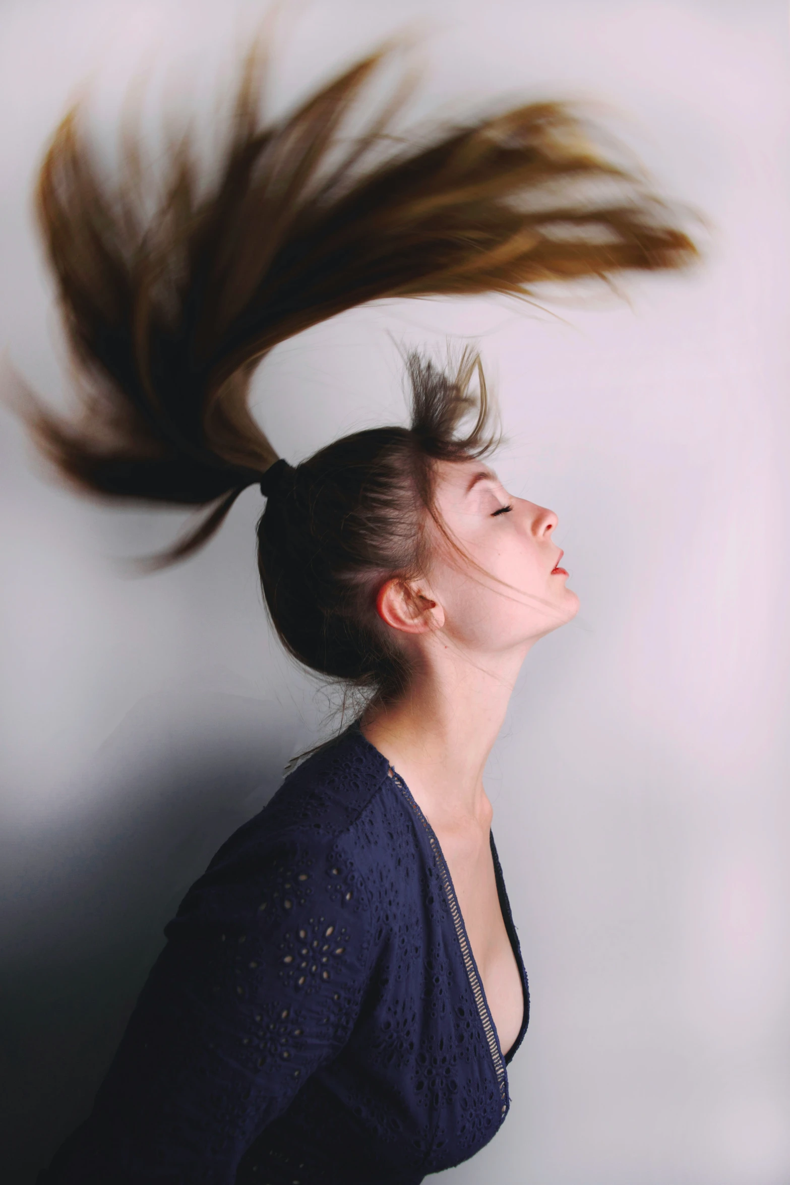 a woman's hair blowing over her head, in a black dress