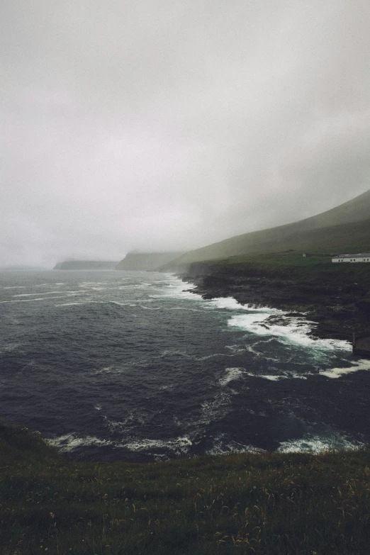 a bench on a field that is next to the ocean