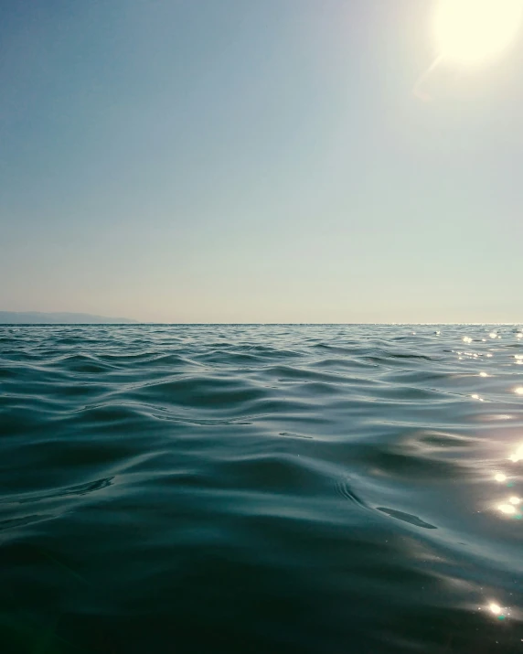 some blue and green water and sky and sun