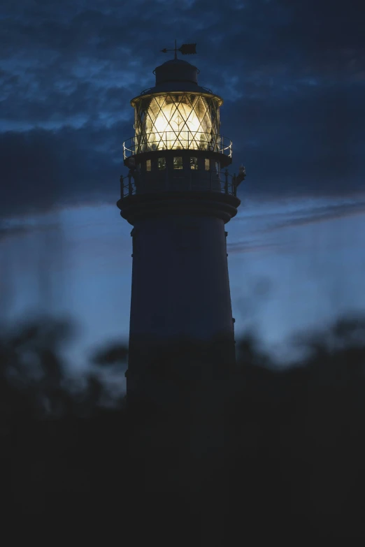 a lighthouse in the moonlight is seen against the sky