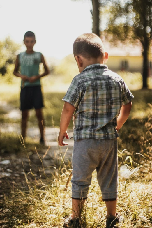 there are two boys standing in the field together