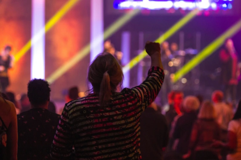 people standing on a stage with their arms up