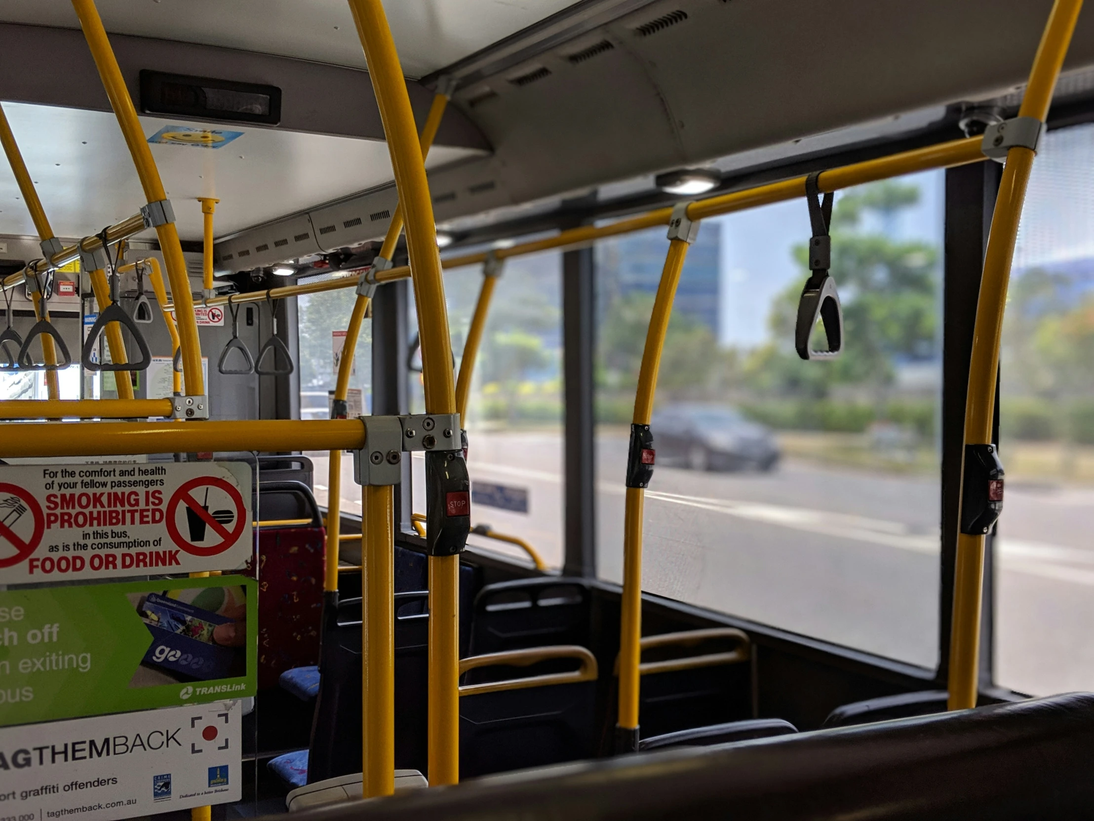 the inside of a bus with signs on its railings