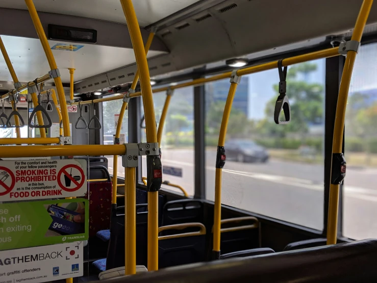 the inside of a bus with signs on its railings