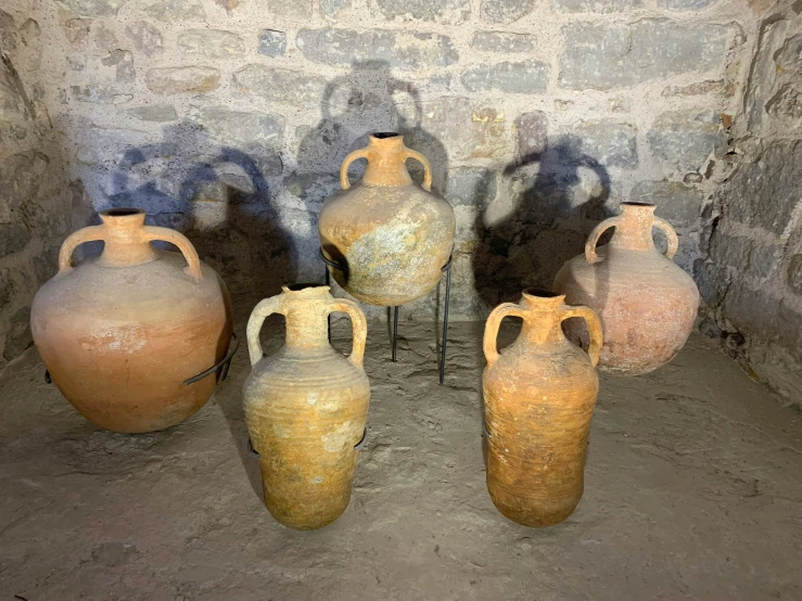 some pots are lined up near a wall