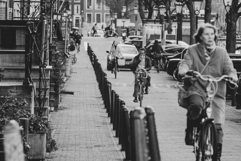 people on bikes riding down the street in the rain