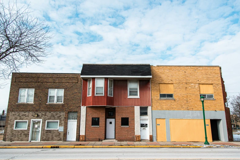 a line of wooden townhouses with boarded up windows