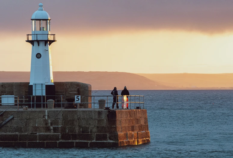 a couple of people standing on top of a long pier