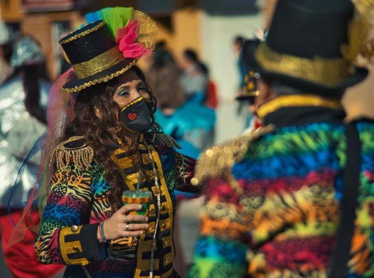 the woman in brightly colored outfit holds onto a beverage