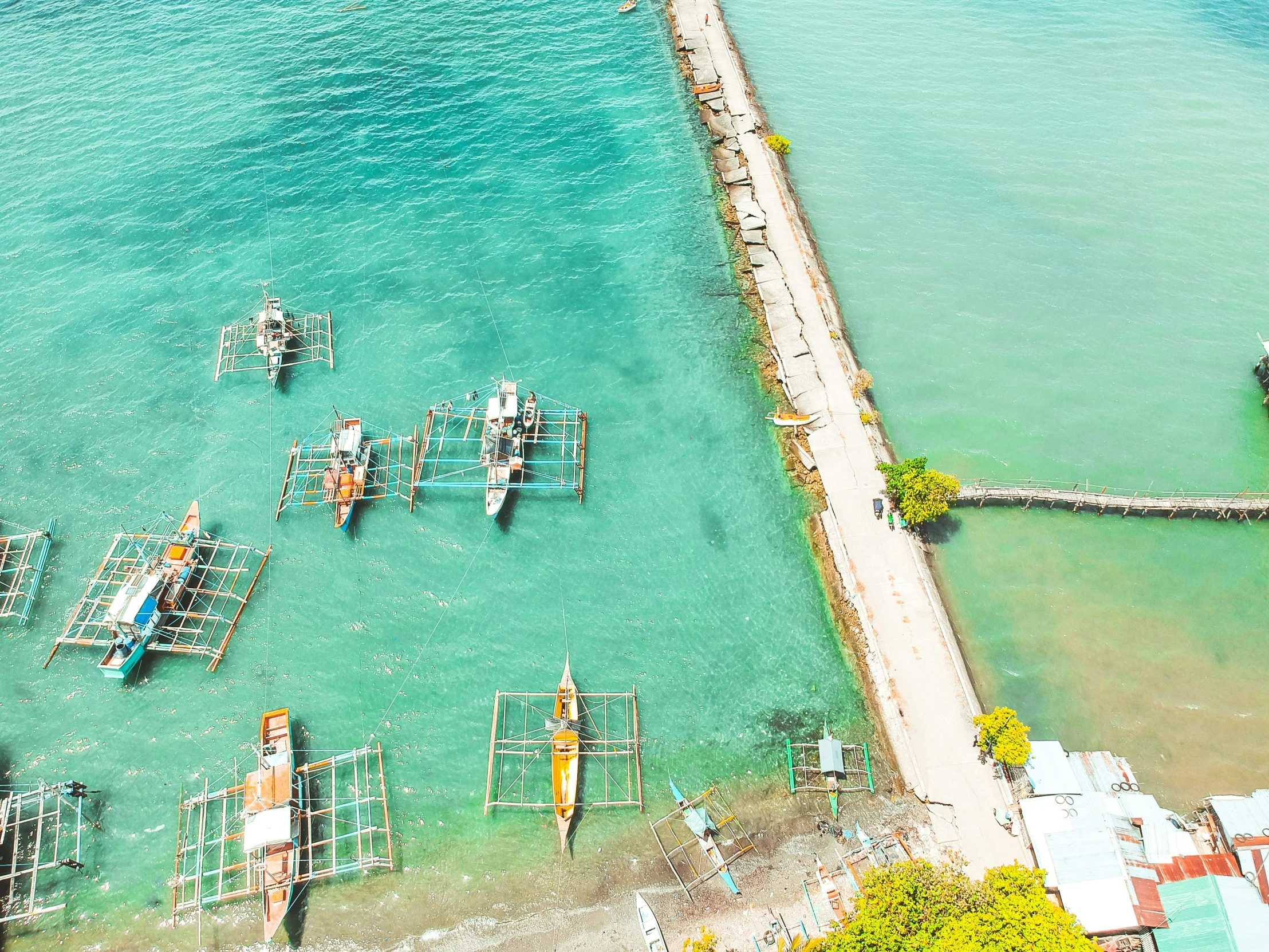 an aerial view of boats docked in clear water