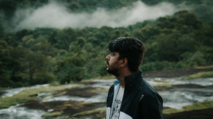 the man is standing on the side of a small hill