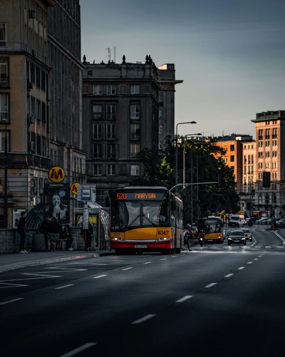 a bus drives along an urban street in the sunset