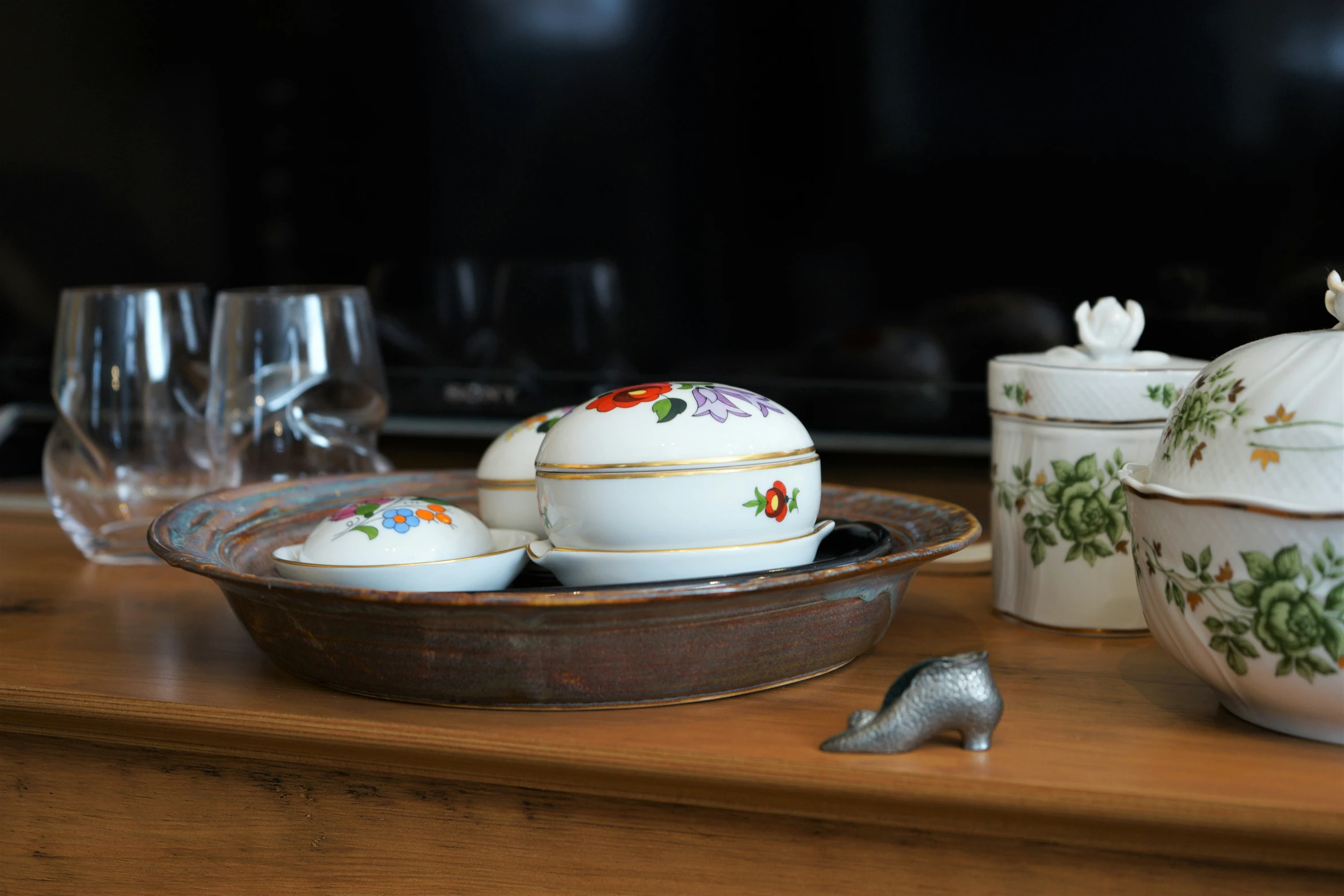 a tray on the table with a tea set and glassware